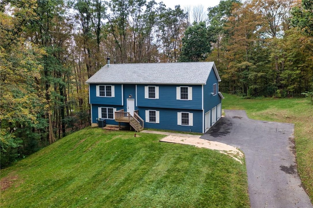 bi-level home with driveway, a front lawn, and a garage