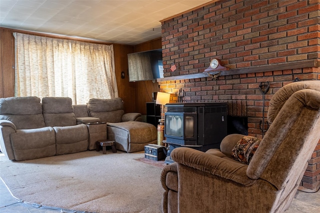 living room with wood walls, a wood stove, and carpet