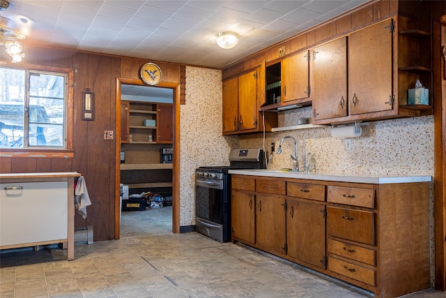 kitchen with gas range, brown cabinets, light countertops, and open shelves