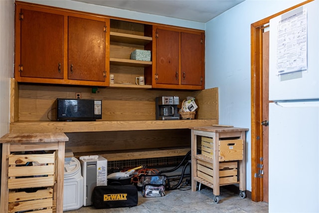 kitchen with brown cabinets, freestanding refrigerator, and open shelves