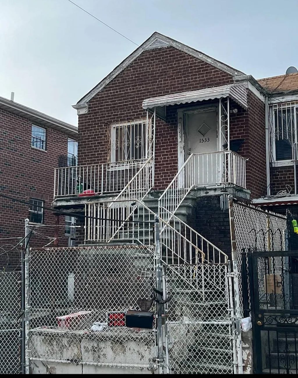 bungalow-style home featuring fence, brick siding, and a gate