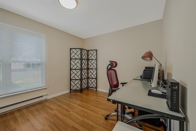 home office featuring light wood-style flooring, a baseboard heating unit, and baseboards