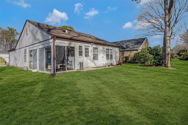 rear view of house with a yard and a sunroom