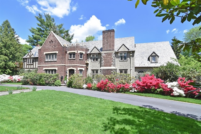 1028 Esplanade, Pelham, NY 10803 - tudor home with a chimney, a high end roof, and a front lawn
