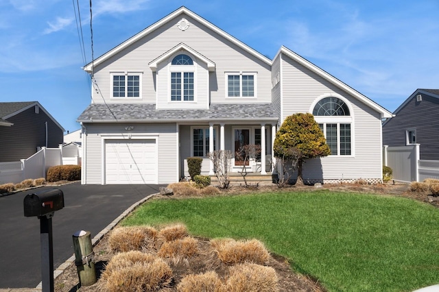 9 Gibbs Rd, Amity Harbor, NY 11701 - view of front of house featuring aphalt driveway, a garage, a front lawn, and fence