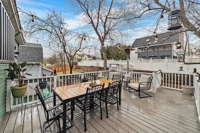 wooden terrace with outdoor dining space and fence