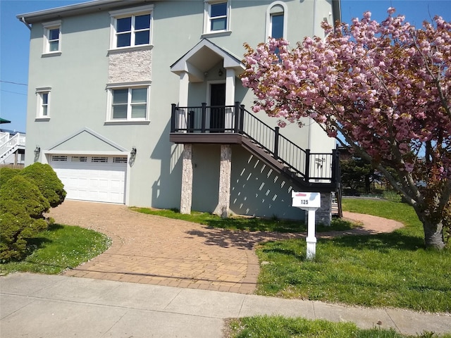 125 S Bay Dr, Babylon, NY 11702 - view of front of house featuring stairs, stucco siding, a garage, and decorative driveway