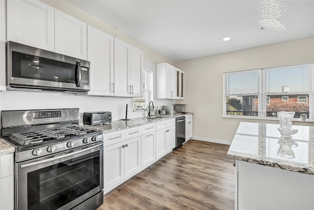 125 S Bay Dr, Babylon, NY 11702 - kitchen with stainless steel appliances, light wood-type flooring, white cabinets, light stone countertops, and recessed lighting
