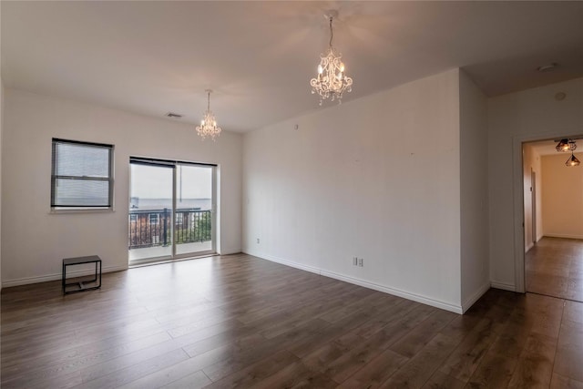 125 S Bay Dr, Babylon, NY 11702 - spare room featuring a chandelier, dark wood-type flooring, and baseboards