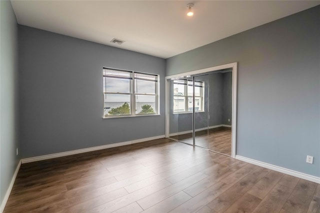 125 S Bay Dr, Babylon, NY 11702 - unfurnished bedroom featuring baseboards, wood finished floors, and a closet