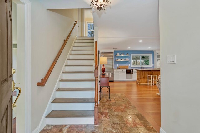 staircase with recessed lighting, wood finished floors, and baseboards