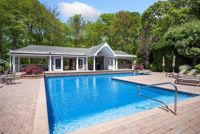 10 Crick Holly Ln, East Islip, NY 11730 - outdoor pool featuring a patio area and view of wooded area
