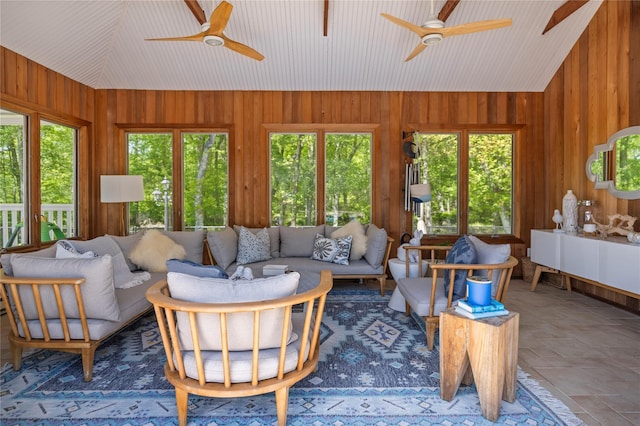 10 Crick Holly Ln, East Islip, NY 11730 - living area featuring vaulted ceiling, a ceiling fan, wood walls, healthy amount of natural light, and stone finish floors