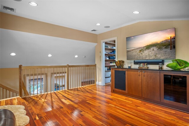 10 Crick Holly Ln, East Islip, NY 11730 - indoor dry bar with wood finished floors, vaulted ceiling, recessed lighting, and beverage cooler