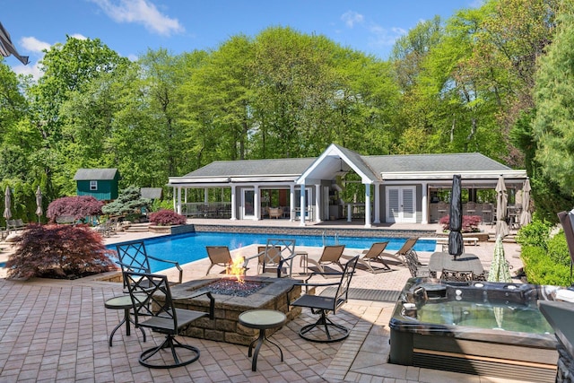 10 Crick Holly Ln, East Islip, NY 11730 - swimming pool featuring a hot tub, a fire pit, an outbuilding, and a patio area