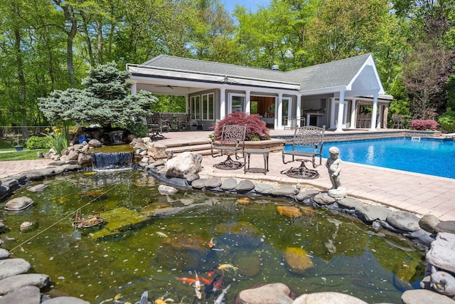 10 Crick Holly Ln, East Islip, NY 11730 - swimming pool with a patio, a storage structure, a small pond, and an outbuilding
