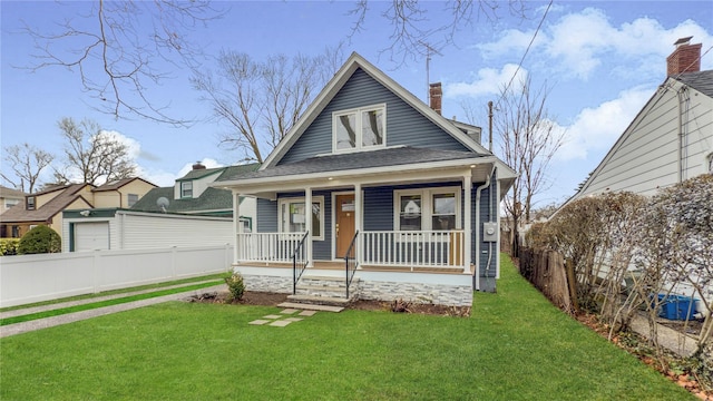 bungalow-style house with a chimney, covered porch, a front yard, and fence