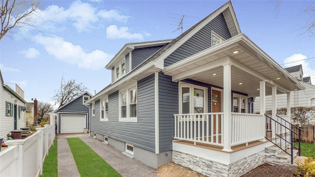 view of side of property featuring an outbuilding, a porch, driveway, and fence