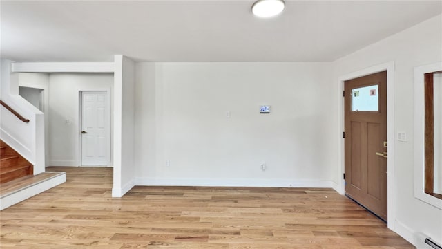 foyer with stairs, light wood-style flooring, baseboards, and baseboard heating