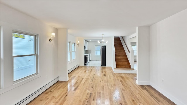 interior space featuring baseboards, a chandelier, stairway, light wood-type flooring, and a baseboard radiator