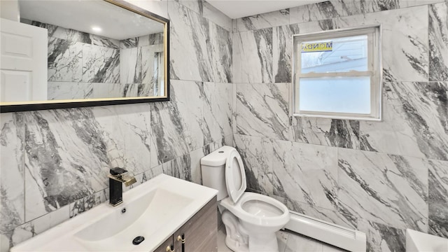 bathroom featuring toilet, vanity, baseboard heating, tile walls, and a shower