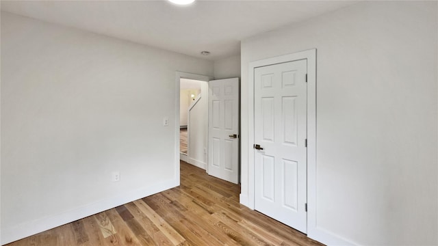 unfurnished bedroom with light wood-type flooring and baseboards