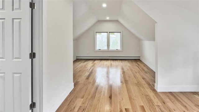 bonus room featuring lofted ceiling, baseboards, light wood-type flooring, and baseboard heating