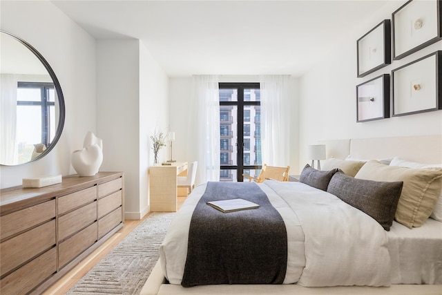 bedroom featuring light wood-style flooring and baseboards