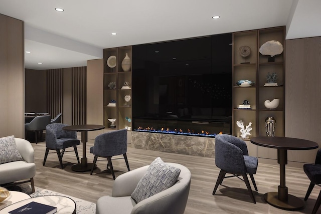 living room with a fireplace, recessed lighting, and light wood-style floors