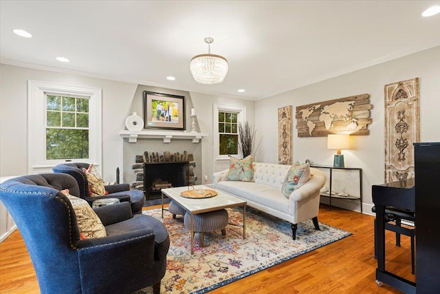 living room featuring crown molding, wood finished floors, and a large fireplace