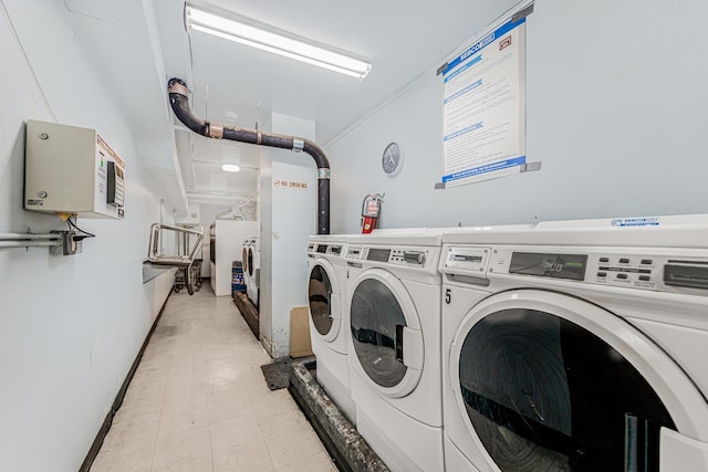 shared laundry area with light floors and washer and clothes dryer
