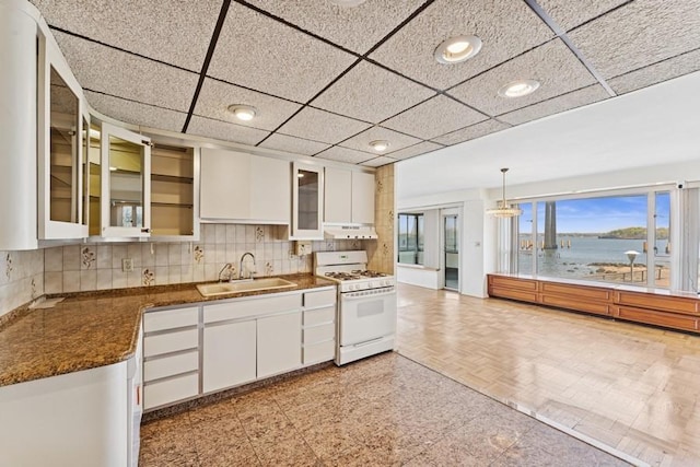 166-25 Powells Cove Blvd Unit 1A, Whitestone, NY 11357 - kitchen featuring white gas range oven, tasteful backsplash, white cabinetry, and a sink