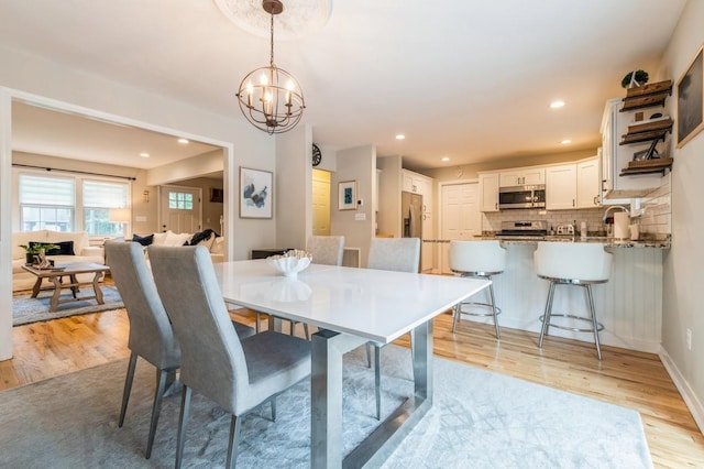 dining space featuring recessed lighting, baseboards, light wood-style floors, and a chandelier