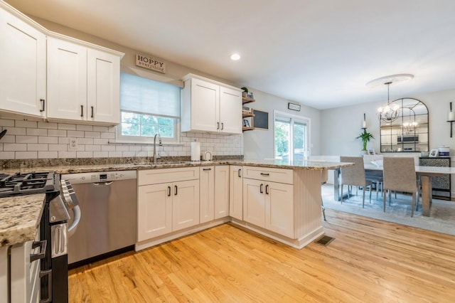 kitchen featuring a sink, white cabinets, light wood finished floors, and stainless steel appliances