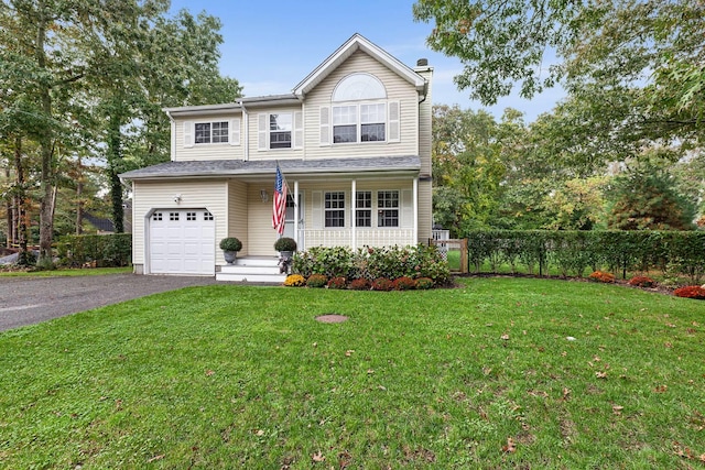 traditional home with fence, driveway, a porch, an attached garage, and a front lawn
