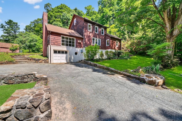 285 Grand St, Croton-On-Hudson, NY 10520 - view of front facade with driveway, a chimney, a front lawn, and an attached garage