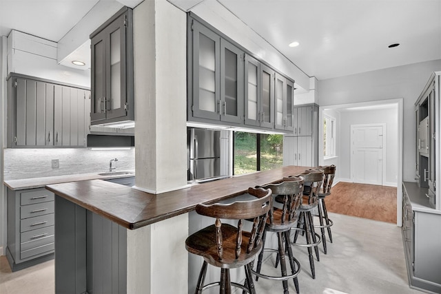 285 Grand St, Croton-On-Hudson, NY 10520 - kitchen with gray cabinets, glass insert cabinets, a breakfast bar area, tasteful backsplash, and recessed lighting