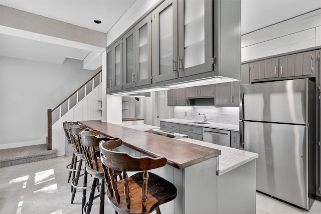 285 Grand St, Croton-On-Hudson, NY 10520 - kitchen featuring appliances with stainless steel finishes, gray cabinets, tasteful backsplash, glass insert cabinets, and a peninsula
