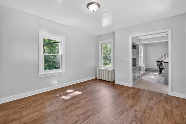 285 Grand St, Croton-On-Hudson, NY 10520 - empty room featuring radiator heating unit, stairs, and wood finished floors