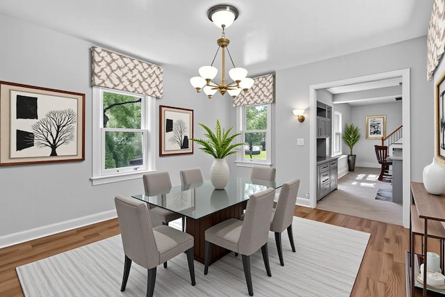 285 Grand St, Croton-On-Hudson, NY 10520 - dining space with a chandelier, light wood-type flooring, and stairway