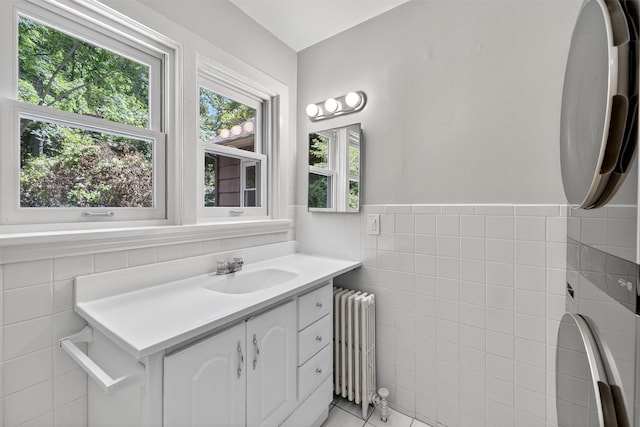 285 Grand St, Croton-On-Hudson, NY 10520 - bathroom with radiator, tile walls, vanity, wainscoting, and tile patterned floors