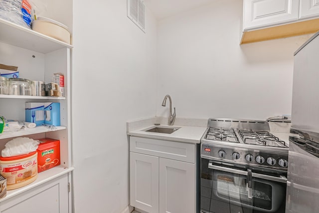 8900 170th St Unit 7N, Jamaica, NY 11432 - kitchen featuring visible vents, light countertops, appliances with stainless steel finishes, white cabinetry, and a sink