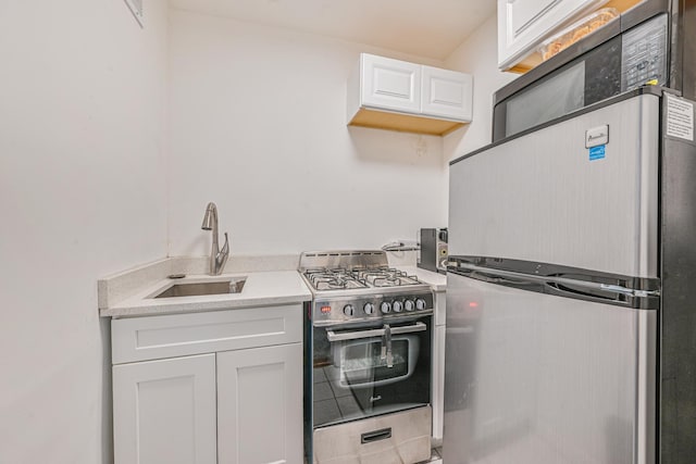 8900 170th St Unit 7N, Jamaica, NY 11432 - kitchen with a sink, stainless steel appliances, white cabinets, and light countertops