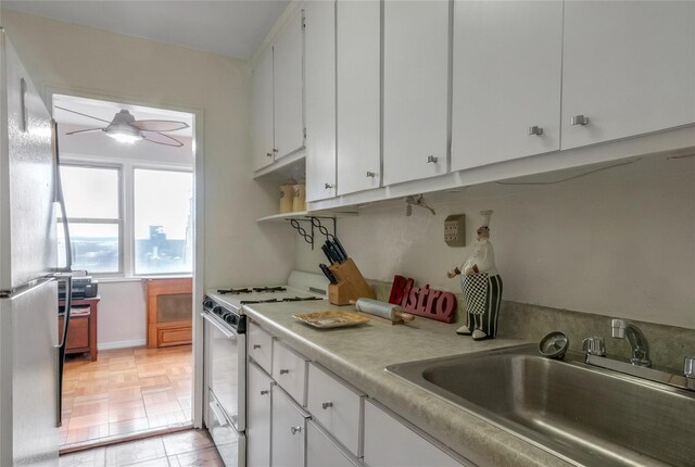 3131 Grand Concourse Unit 11J, Bronx, NY 10468 - kitchen featuring ceiling fan, white gas stove, light countertops, freestanding refrigerator, and a sink