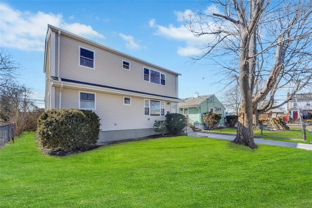 7 Howard Ave, Freeport, NY 11520 - back of property featuring a playground, a yard, and fence