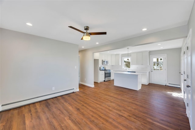 7 Howard Ave, Freeport, NY 11520 - unfurnished living room with recessed lighting, dark wood-style flooring, and a baseboard radiator