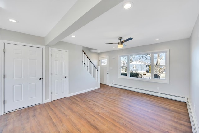 7 Howard Ave, Freeport, NY 11520 - unfurnished living room featuring recessed lighting, a baseboard radiator, wood finished floors, and stairs