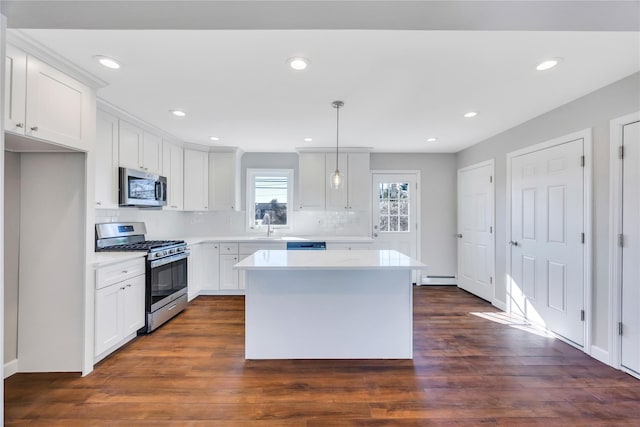7 Howard Ave, Freeport, NY 11520 - kitchen with dark wood finished floors, decorative backsplash, appliances with stainless steel finishes, and light countertops