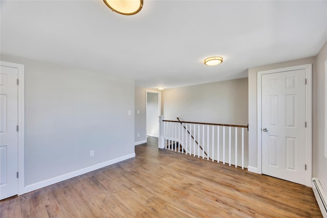 7 Howard Ave, Freeport, NY 11520 - unfurnished room featuring a baseboard heating unit, wood finished floors, and baseboards