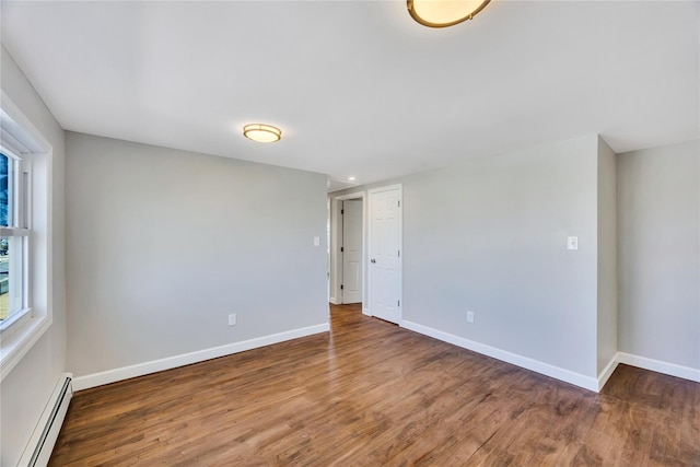 7 Howard Ave, Freeport, NY 11520 - empty room featuring a baseboard heating unit, baseboards, and wood finished floors